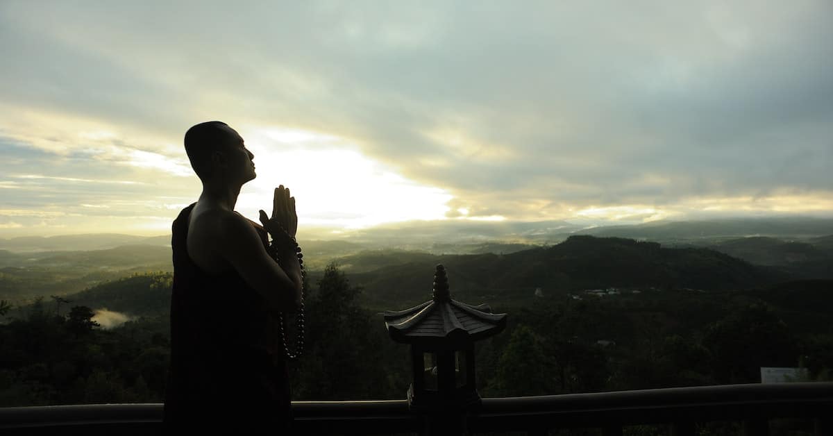 monk praying in beautiful landscape
